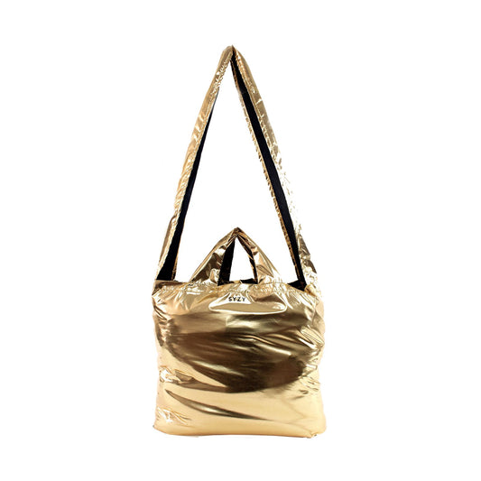 A SYZY Tetra Metallic Gold foldable tote bag with a black strap is displayed against a white background.