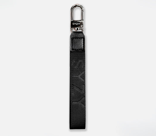 Close-up of a black SYZY Syndeo wrist strap with a silver clasp, featuring the SYZY logo.