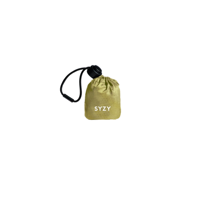 SYZY Ochre Tetra Tote Bag is stored inside a compact camo pouch with a drawstring against a transparent background.