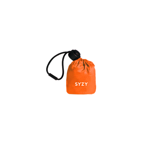 Torii Orange Tetra Tote Bag is stored inside a compact orange pouch with a drawstring against a transparent background.